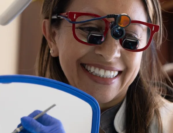 Dentist smiling while caring for a patient